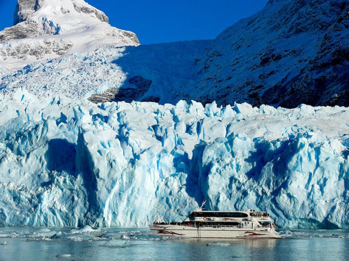Barco navegando junto al glaciar Perito Moreno en Parque Nacional Los Glaciares de Argentina