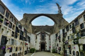 Ruinas de la antigua iglesia parroquial de Comillas integradas entre las tumbas del cementerio